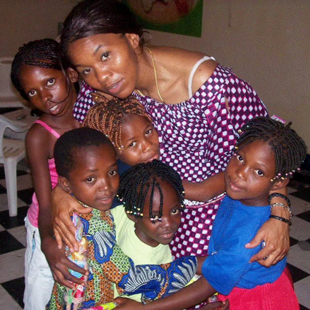 Theresa hugging a group of young children
